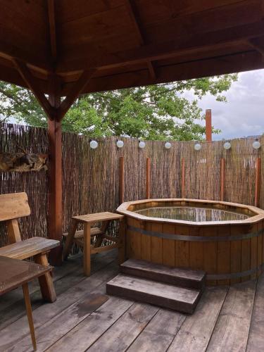a wooden deck with a hot tub and a wooden fence at Kwatera Pod Bukowa Gora in Zwierzyniec