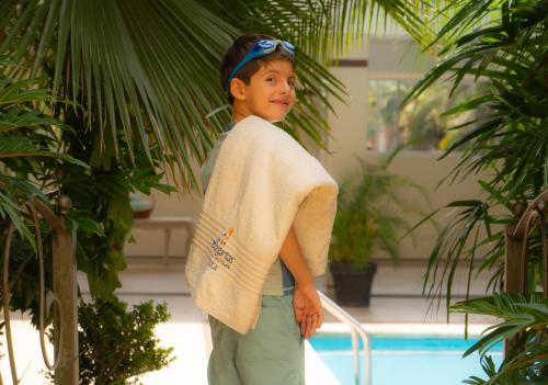 a young boy standing next to a swimming pool at Villa Las Margaritas Caxa in Xalapa