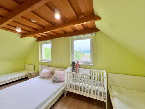a small room with a crib and a window at Drevenica Nela - Chalet in Tatras in Zuberec