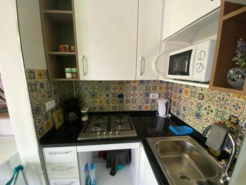 a small kitchen with a sink and a microwave at Marsa-Sidi Bousaid Cosy Authentic Apartment in La Marsa