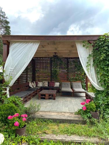 a pavilion with a table and chairs on a patio at Kwatera Pod Bukowa Gora in Zwierzyniec