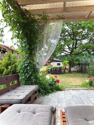 a pergola with a bench on a patio at Kwatera Pod Bukowa Gora in Zwierzyniec