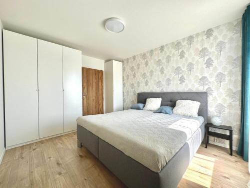 a bedroom with a large bed and a wall at City appartment AC & Parking in Prievoz