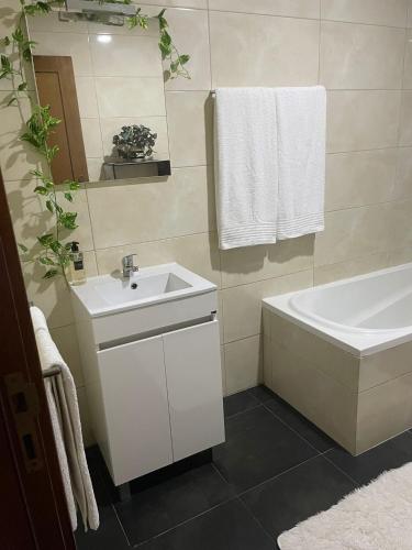 a bathroom with a sink and a tub and a toilet and a mirror at Alojamento Local Afonso in Macedo de Cavaleiros