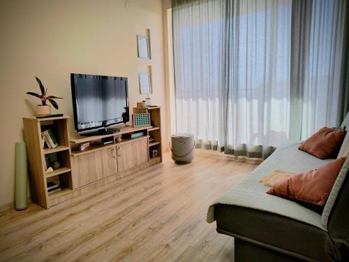 a living room with a flat screen tv and a couch at sea view hygge - Quiet residential apartment in Kavarna