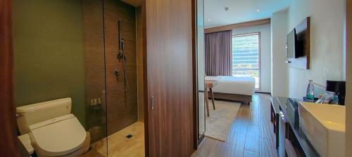 a bathroom with a toilet and a sink and a bed at FUJITAYA Querétaro in Querétaro