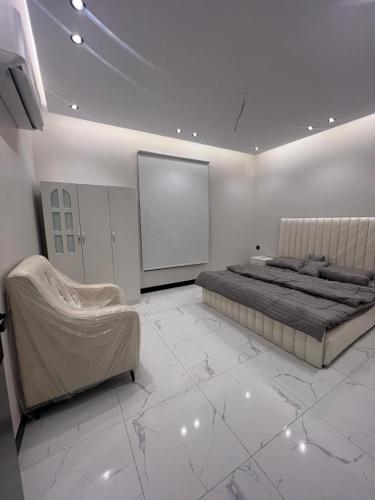 a white bedroom with a bed and a screen at Summo bilding in Jeddah