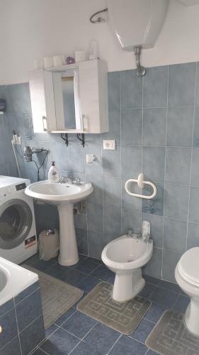 a bathroom with two sinks and a toilet and a washing machine at il Ciclope di Annalisa in Alatri