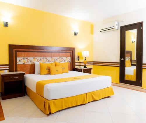a bedroom with a large bed with yellow walls at Villa Las Margaritas Caxa in Xalapa