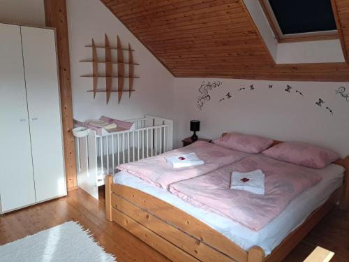 a bedroom with a large bed with pink sheets at Kismarosi Center Apartman in Kismaros