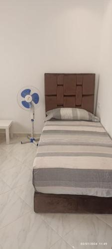 a bedroom with a bed and a fan on the floor at Residence Al-Bahr etage 4 floor 4 in M'diq
