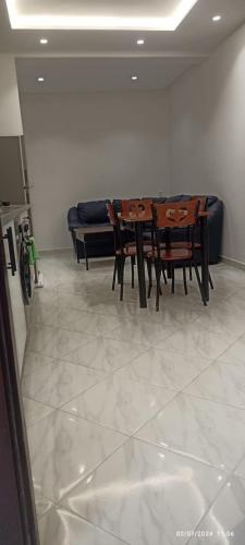 a dining room with a table and a couch at Residence Al-Bahr etage 4 floor 4 in M'diq