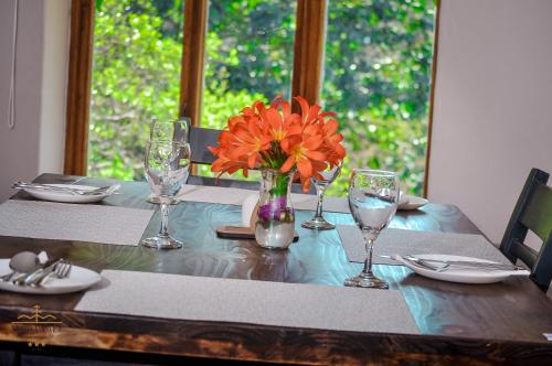a table with a vase of orange flowers on it at Avoca Vale Country Hotel in Louis Trichardt