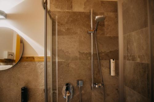 a shower with a glass door in a bathroom at Hotel Alpin Tyrol - Kitzbüheler Alpen in Sankt Johann in Tirol