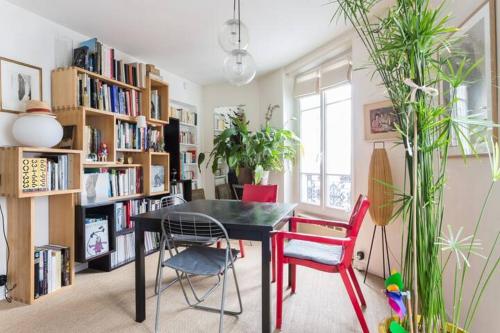 une chambre avec une table, des chaises et des étagères dans l'établissement Grand appart d'angle - Montmartre Moulin Galette, à Paris