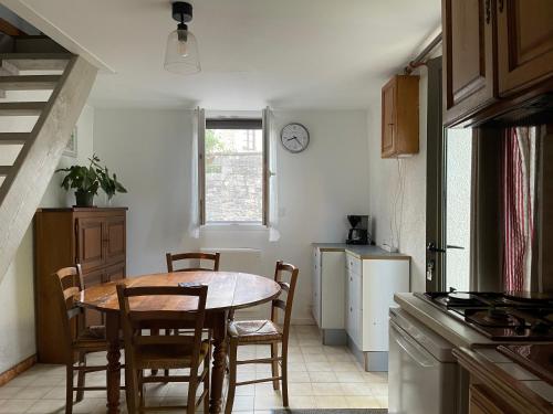 une cuisine avec une table et des chaises dans une pièce dans l'établissement La petite maison dans le jardin, à Bournazel