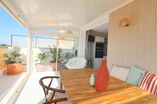 une salle à manger avec une table en bois et un balcon dans l'établissement Rare! Oasis Btw Old Antibes & Beach, à Antibes
