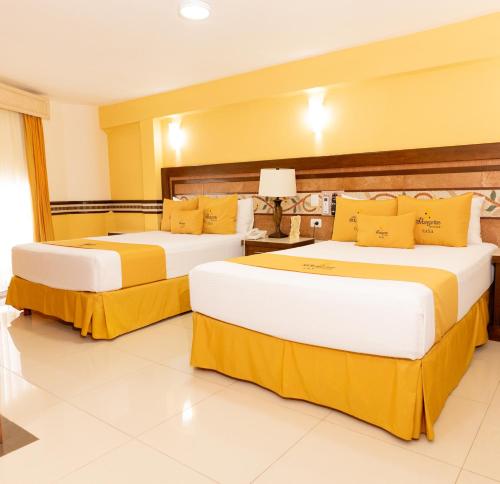 two beds in a hotel room with yellow pillows at Villa Las Margaritas Caxa in Xalapa