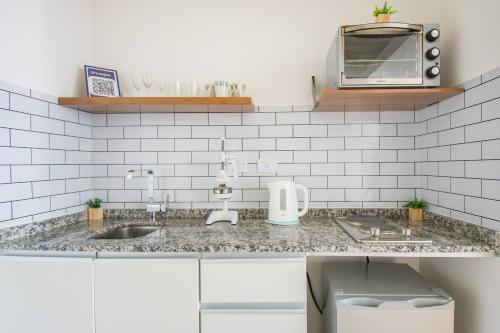 un bancone da cucina con lavello e microonde di Nova Stays - Downtown Studio - Buenos Aires a Buenos Aires