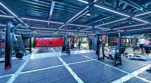 Un gimnasio con máquinas y gente haciendo ejercicio en él. en Xliving Host and Rooms, en Bogotá