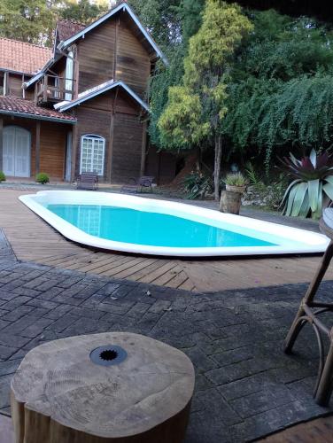 a swimming pool in front of a house at Pássaro de Fogo in Santo Antônio do Pinhal