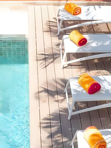 a pool with chaise lounge chairs next to a swimming pool at Casa Riviera in Bucerías