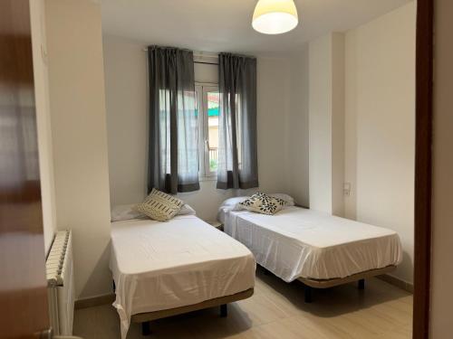 a room with two beds and a window at Costapera in La Pobla de Segur