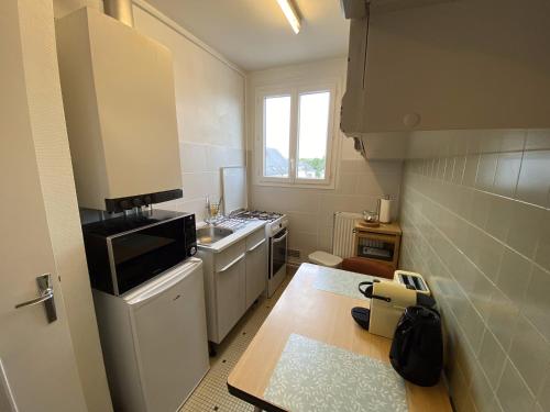 une petite cuisine avec un évier et une cuisinière dans l'établissement Grand studio calme avec balcon & parking gratuit, à Tours