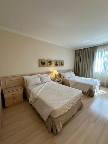 a hotel room with two beds and a window at Hotel Saint Paul in Sao Jose do Rio Preto
