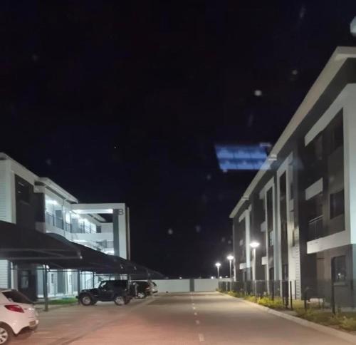 a parking lot next to a building at night at Kastina Suites in Gaborone