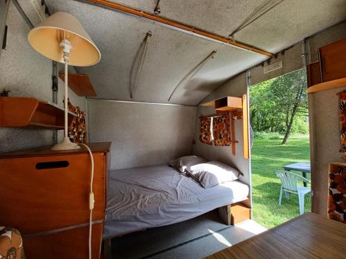 une chambre dans une caravane avec un lit dedans dans l'établissement Caravane vintage, à Pornichet