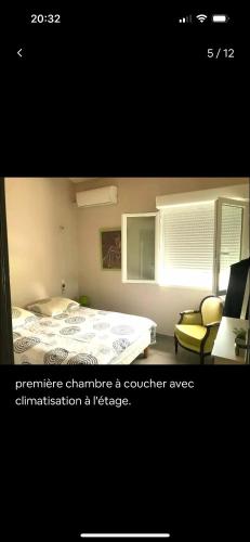 une chambre avec un lit, une chaise et une fenêtre dans l'établissement Maison les pieds dans L'eau, à Marseillan