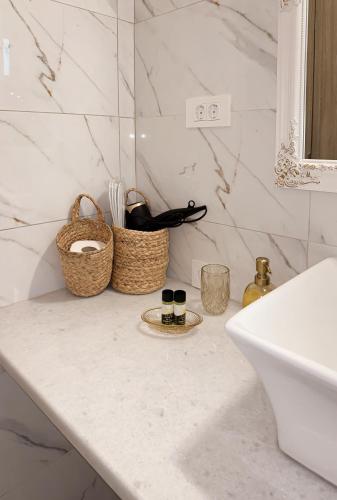 a bathroom counter with two bottles and baskets on it at Thetis, the Beach House in Nafplio