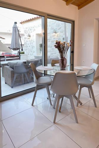 a dining room with tables and chairs and a patio at Thetis, the Beach House in Nafplio