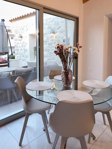 a dining room with a glass table and chairs at Thetis, the Beach House in Nafplio