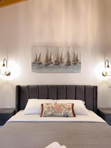 a bedroom with a bed with a painting of sailboats at Thetis, the Beach House in Nafplio