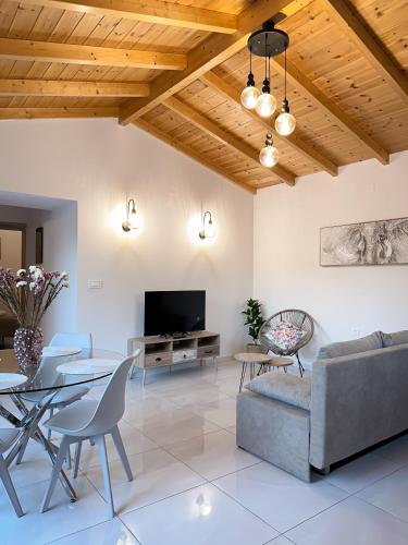 a living room with a table and chairs and a tv at Thetis, the Beach House in Nafplio
