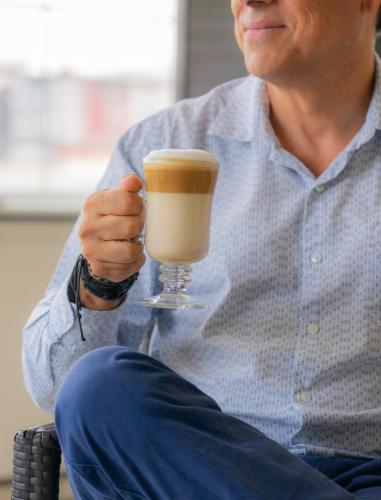 a man is holding a glass of coffee at Villa Las Margaritas Caxa in Xalapa