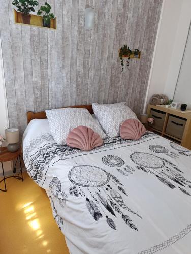 - un lit avec une couette en noir et blanc et des oreillers roses dans l'établissement Maison avec piscine dans résidence, à Béziers