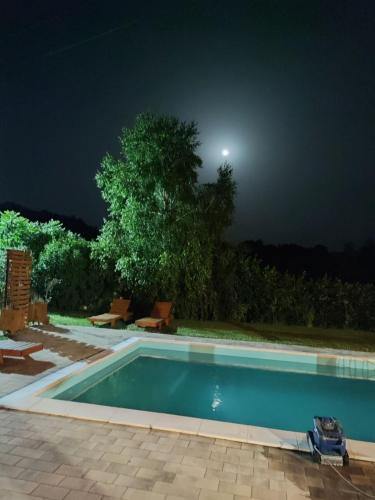 a swimming pool at night with the moon in the sky at Srce Kozare in Prijedor