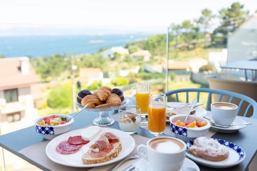 - Mesa con desayuno y bebidas en el balcón en Hotel Mirador Ría de Arosa, en Reboredo