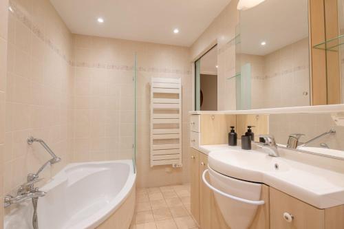 une salle de bain avec un lavabo et une baignoire dans l'établissement Georges III - Apartment with panoramic view of Cannes, à Cannes