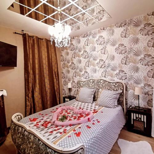 - une chambre avec un lit orné de roses dans l'établissement Romantisme et glamour avec spa ,jardin proche zénith, à Dijon
