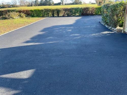 an empty road with trees and bushes on the side at GITE DE L'ORCHIDÉE P M r in Locmaria-Grand-Champ