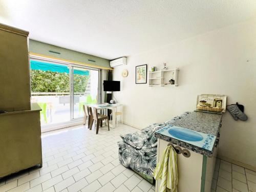 - une cuisine avec un comptoir et une table dans une pièce dans l'établissement Villegiales Tee1 - Appartement climatisé dans résidence avec piscine MAE-1104, à La Grande Motte