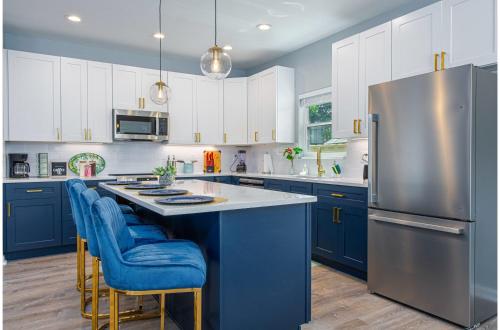 a kitchen with blue cabinets and a stainless steel refrigerator at Heaven-sent Convenient 4BR 3BA Near Downtown in San Antonio