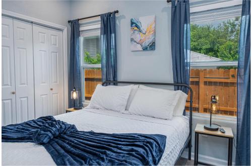 1 dormitorio con 1 cama con cortinas azules y ventana en Heaven-sent Convenient 4BR 3BA Near Downtown, en San Antonio