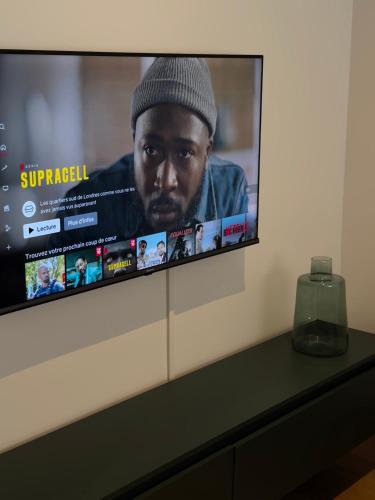 un téléviseur à écran plat posé sur une table dans l'établissement Appartement moderne, à Dijon
