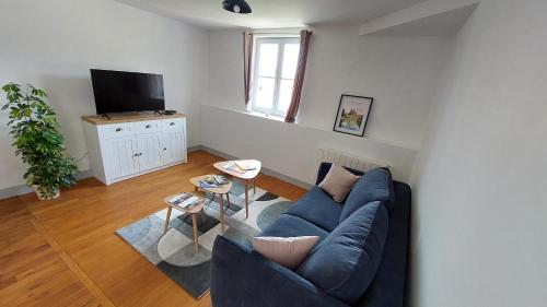 un salon avec un canapé bleu et une télévision dans l'établissement Aux'Cerfs - Vue cathédrale, à Auxerre