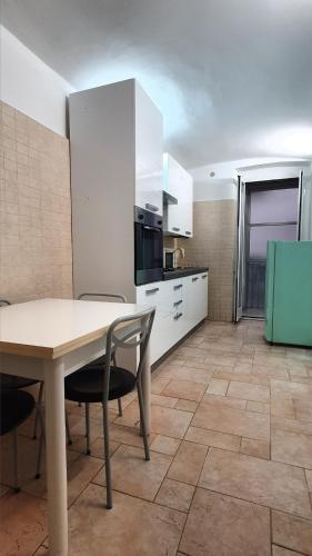 a kitchen with white cabinets and a table and chairs at La Domvs del Borgo in Taranto